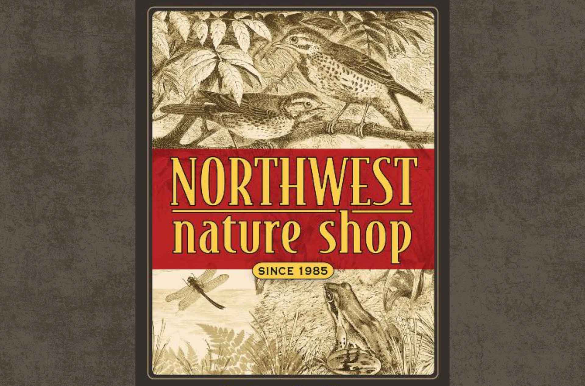 Alt text:  Vintage-style Northwest Nature Shop sign featuring illustrated birds, a dragonfly, and a frog, with the text “Northwest Nature Shop Since 1985” on a red banner.