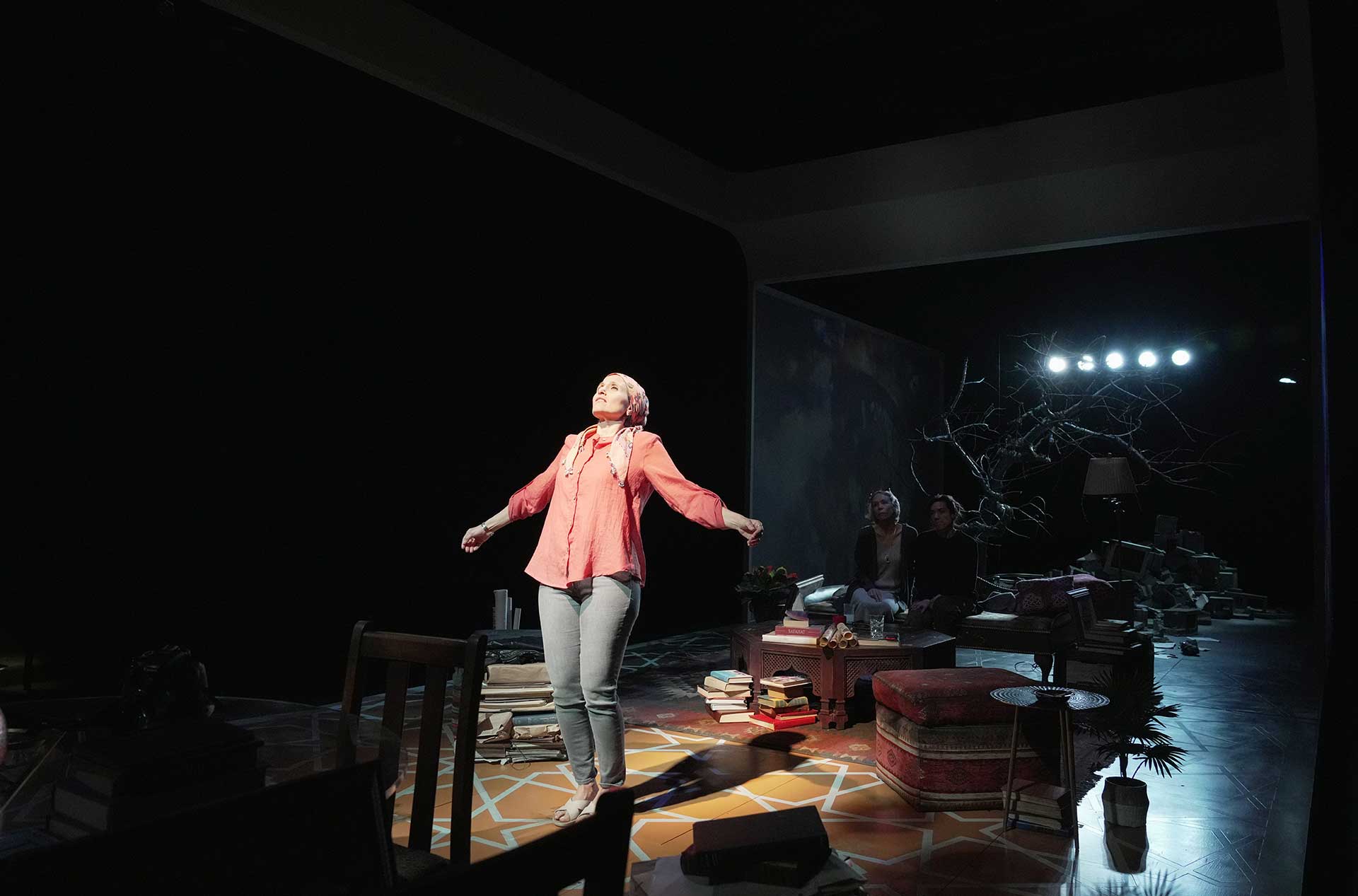 A person on stage with their arms open wide looking to the sky.