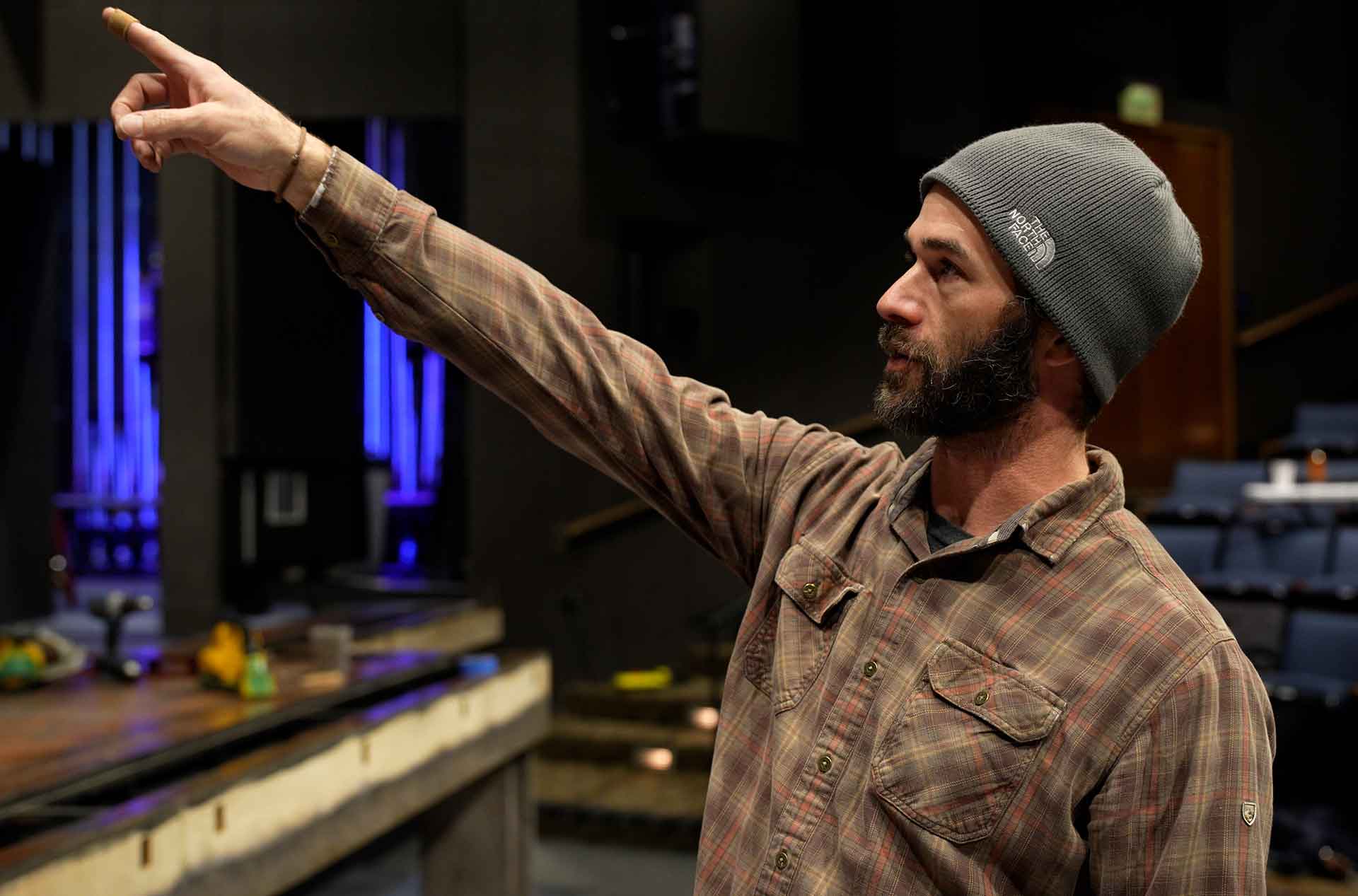 A person pointing and looking to the left.