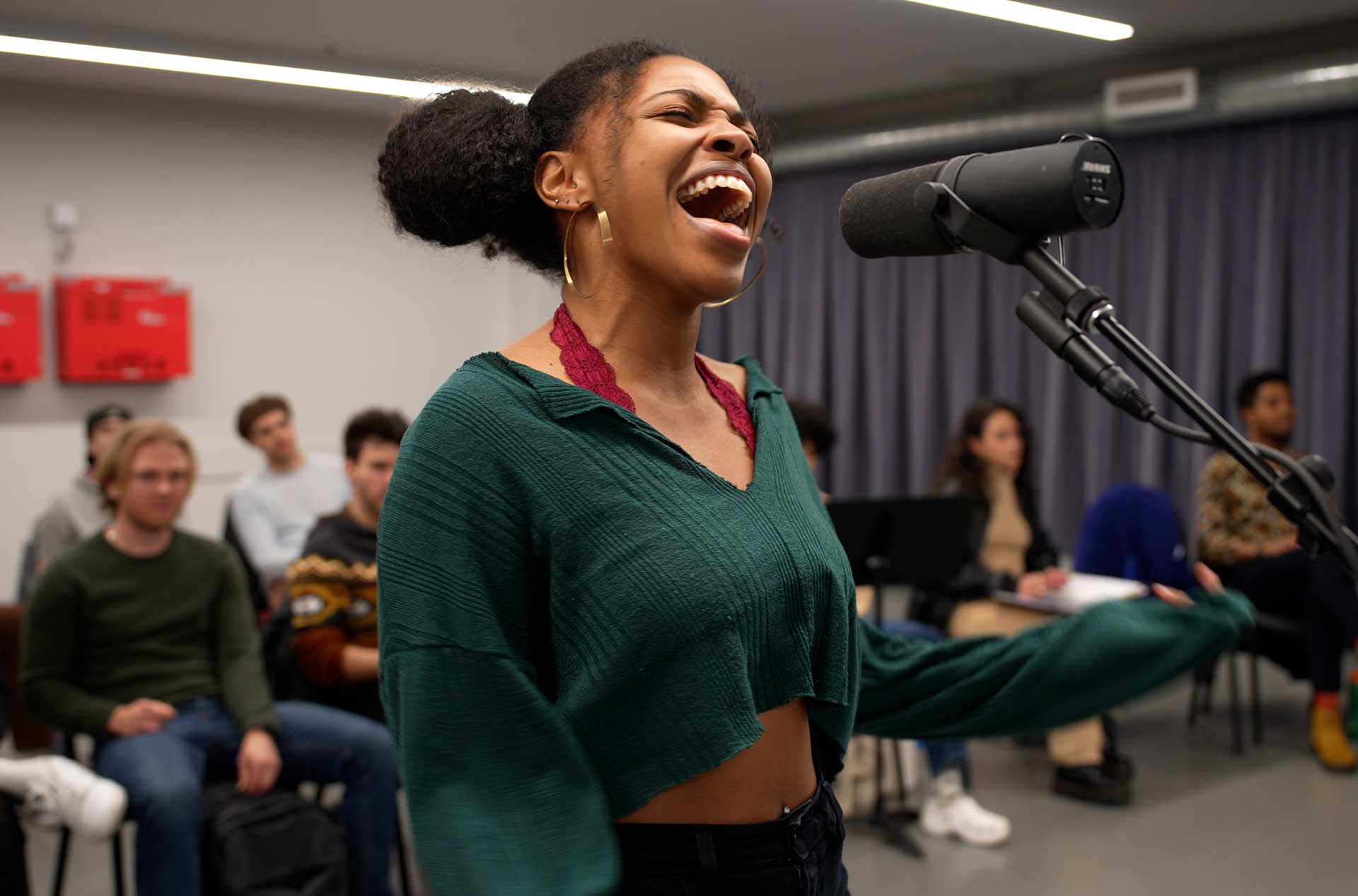 Actor singing into a microphone.