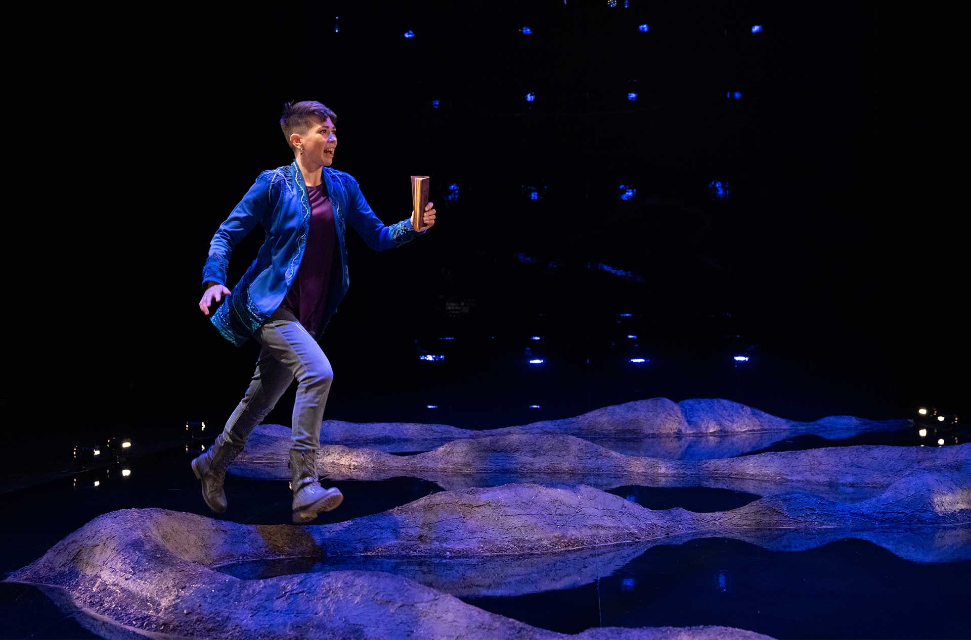 A person standing on the stage looking out toward the audience. 