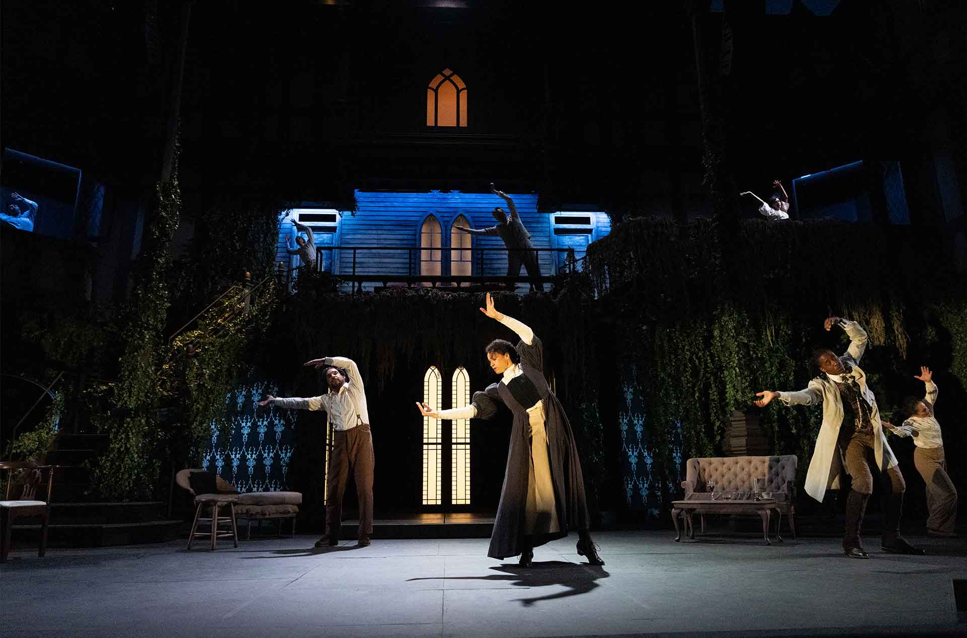 People dancing with their arms in the air in a swaying motion.