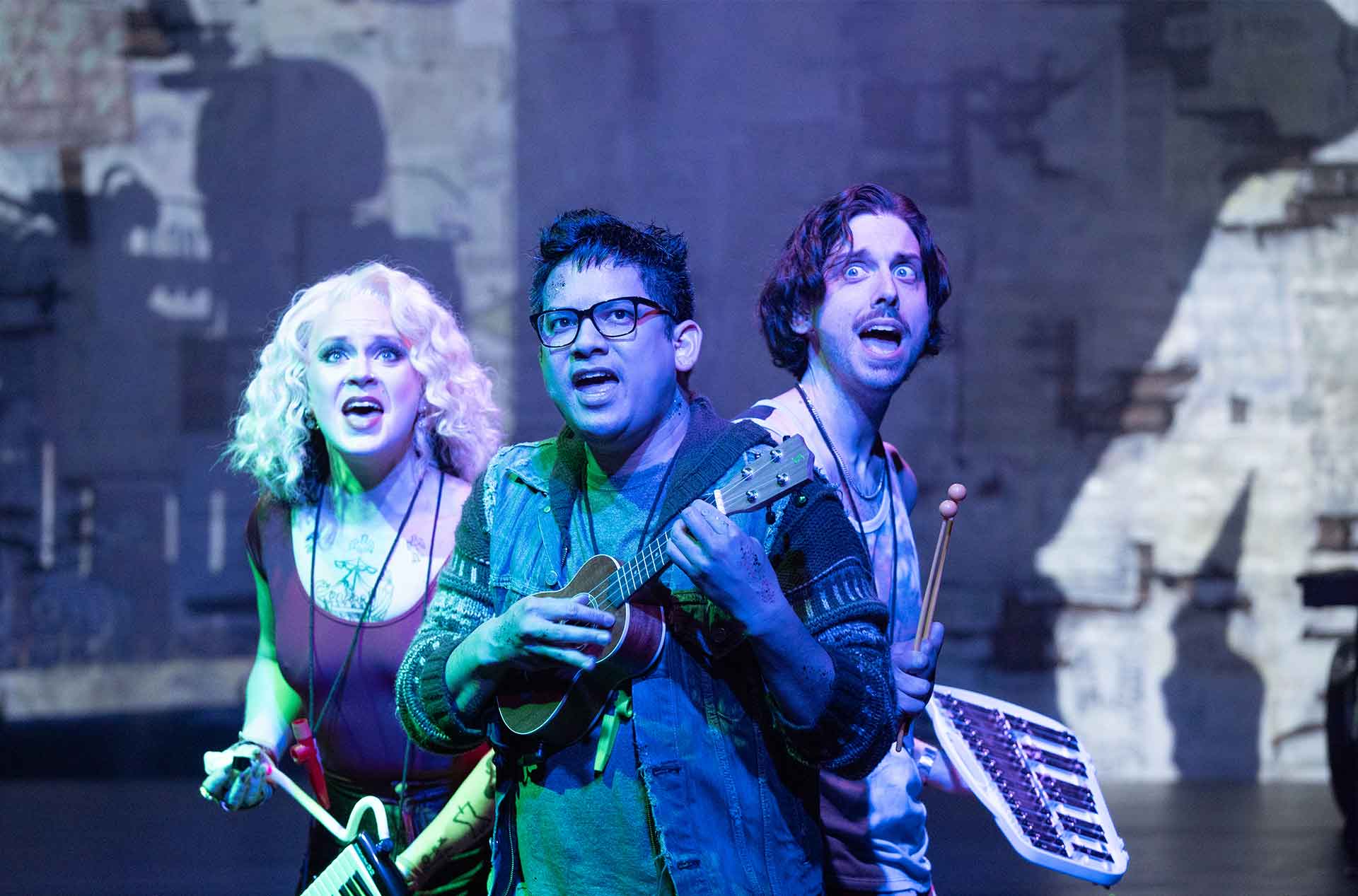 Three people with their backs to each other holding instraments looking at something in the distance.