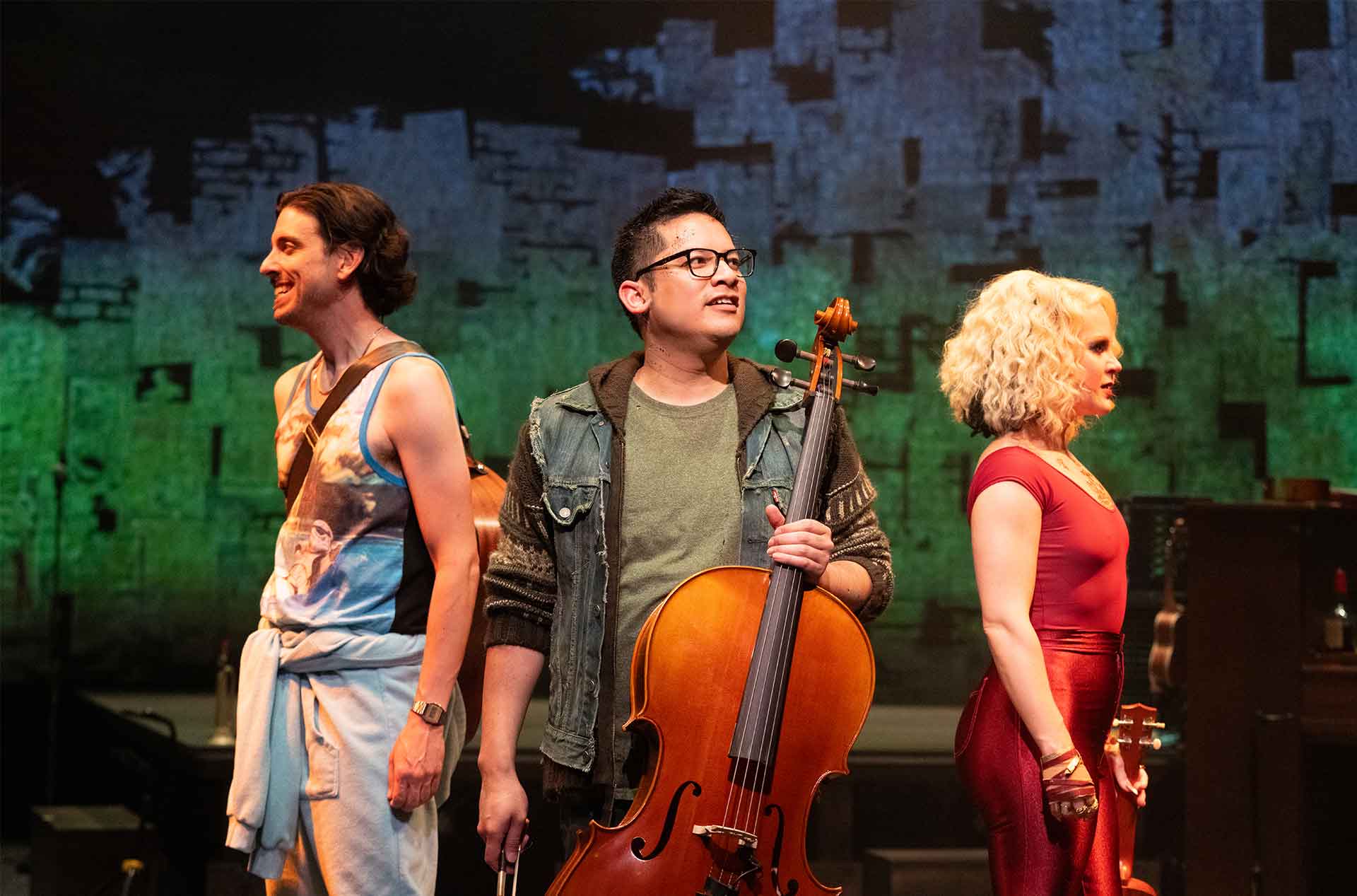 Three people standing back to back each holding musical instraments.