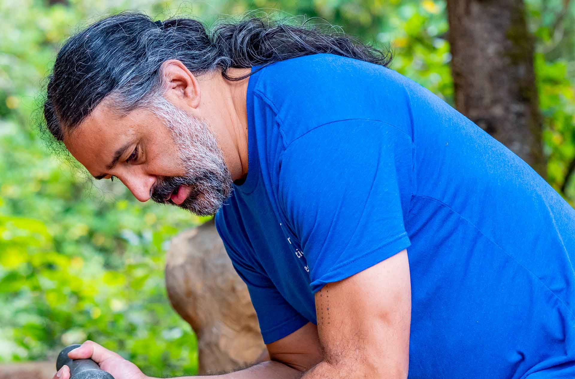 A person carving wood with a hammer and chizel.