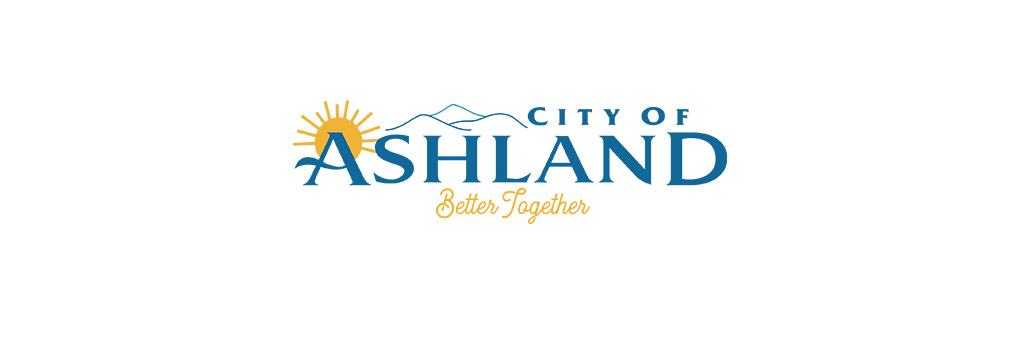 City of Ashland written in blue with a yellow sun over the A and line mountains in the background. 