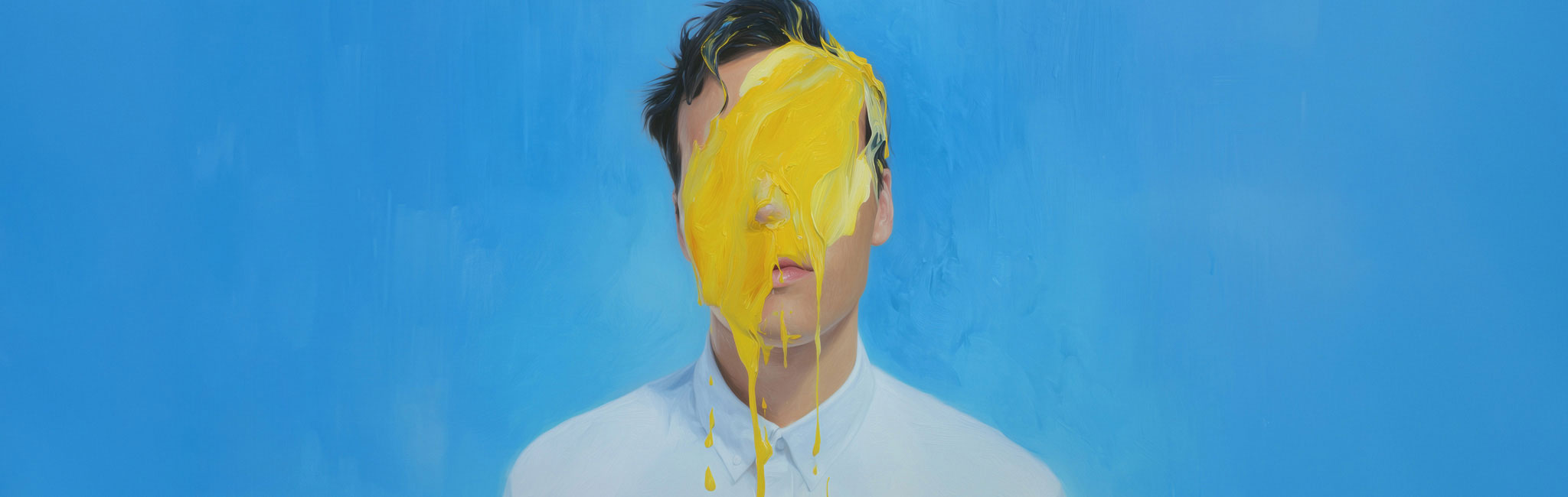 A person in a white shirt stands with their face obscured by a dramatic splash of yellow paint against a smooth blue background.