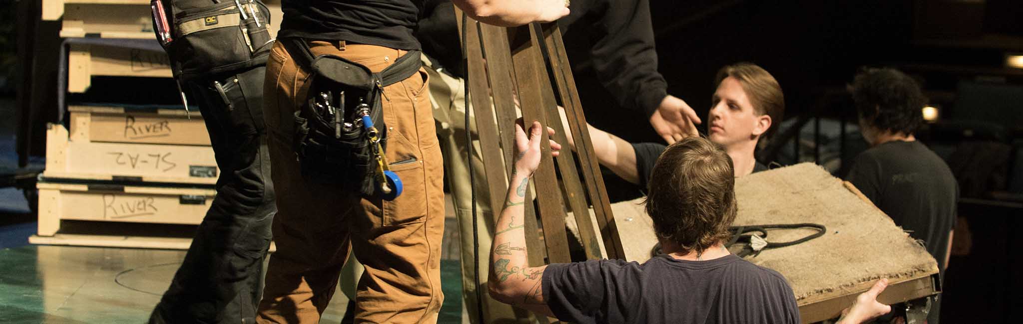 A group of people carrying a prop.